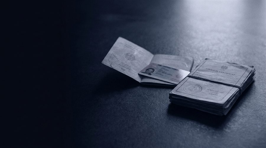 Passaporte e certidões sobre uma mesa.